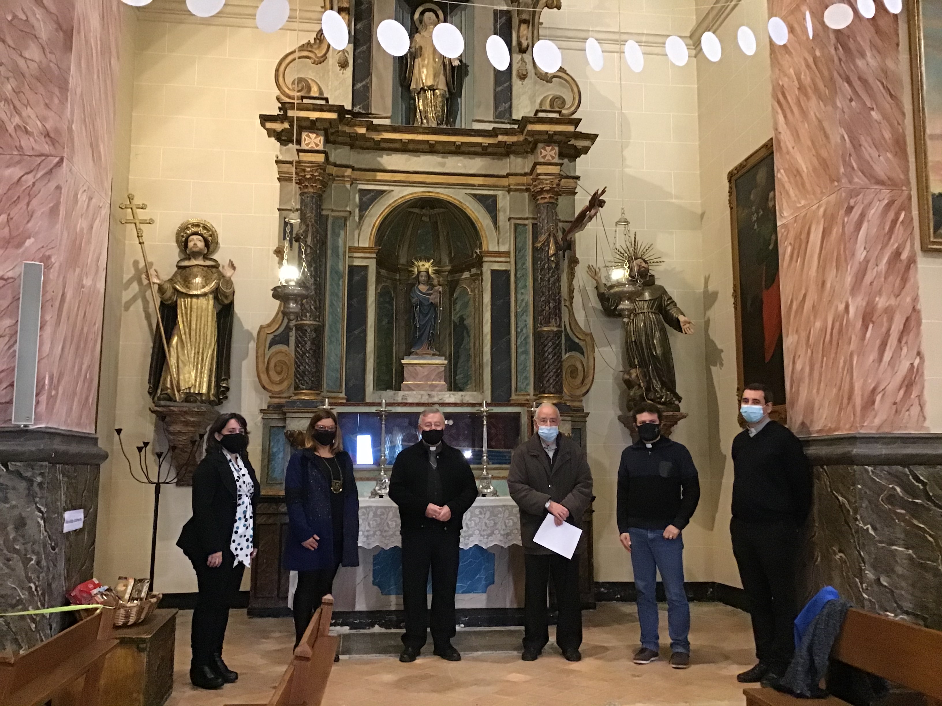 Foto de família davant les imatges de Sant Francesc i Sant Domènec, restaurades gràcies a la col·laboració del Consell i el Bisbat