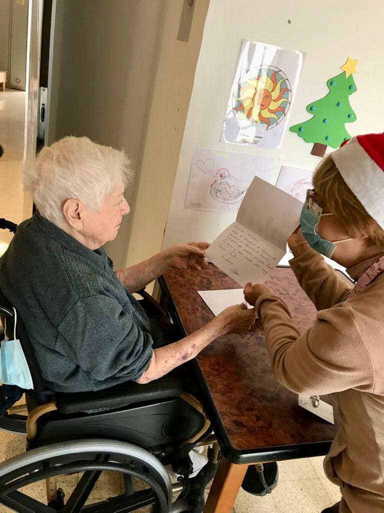 Una treballadora mostra la seva postal personalitzada a una resident de la Llar d'Ancians  